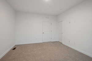 Carpeted empty room featuring baseboards