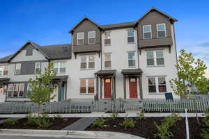 Traditional-style house featuring a fenced front yard, stucco siding, and a gate