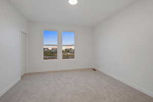 Unfurnished room featuring light colored carpet and baseboards