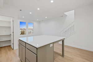 Kitchen featuring gray cabinetry, a center island, recessed lighting, and light wood-style floors