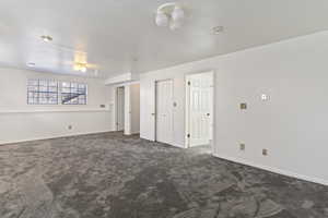 Unfurnished bedroom with dark carpet and a closet