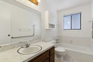 Bathroom with a garden tub, vanity, and light tile patterned flooring