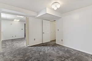 Below grade area featuring dark colored carpet