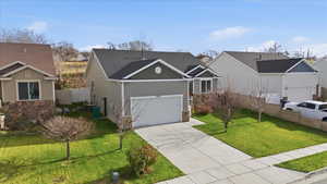 View of front facade with stone siding, driveway, an attached garage, and board and batten siding