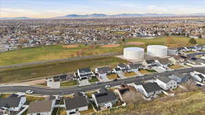 Aerial view of property and surrounding area with nearby suburban area and a mountain backdrop