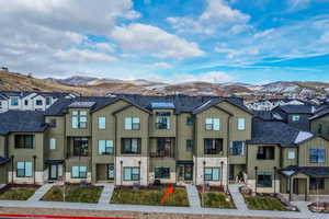 View of front of property with board and batten siding, stone siding, and a mountain view