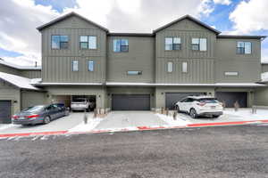 View of back of property featuring board and batten siding and driveway