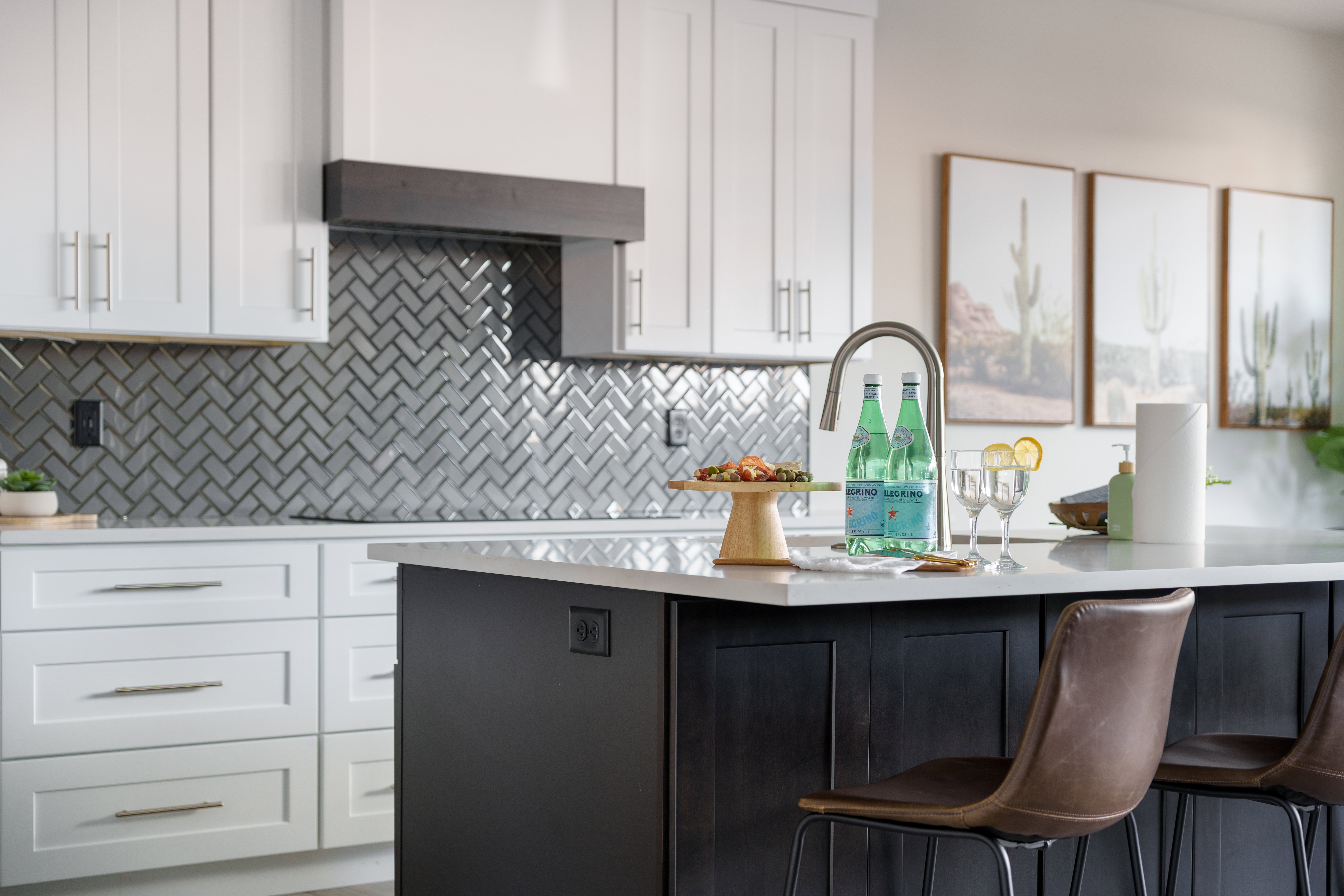 Kitchen featuring white cabinetry, a breakfast bar area, tasteful backsplash, and light stone counters