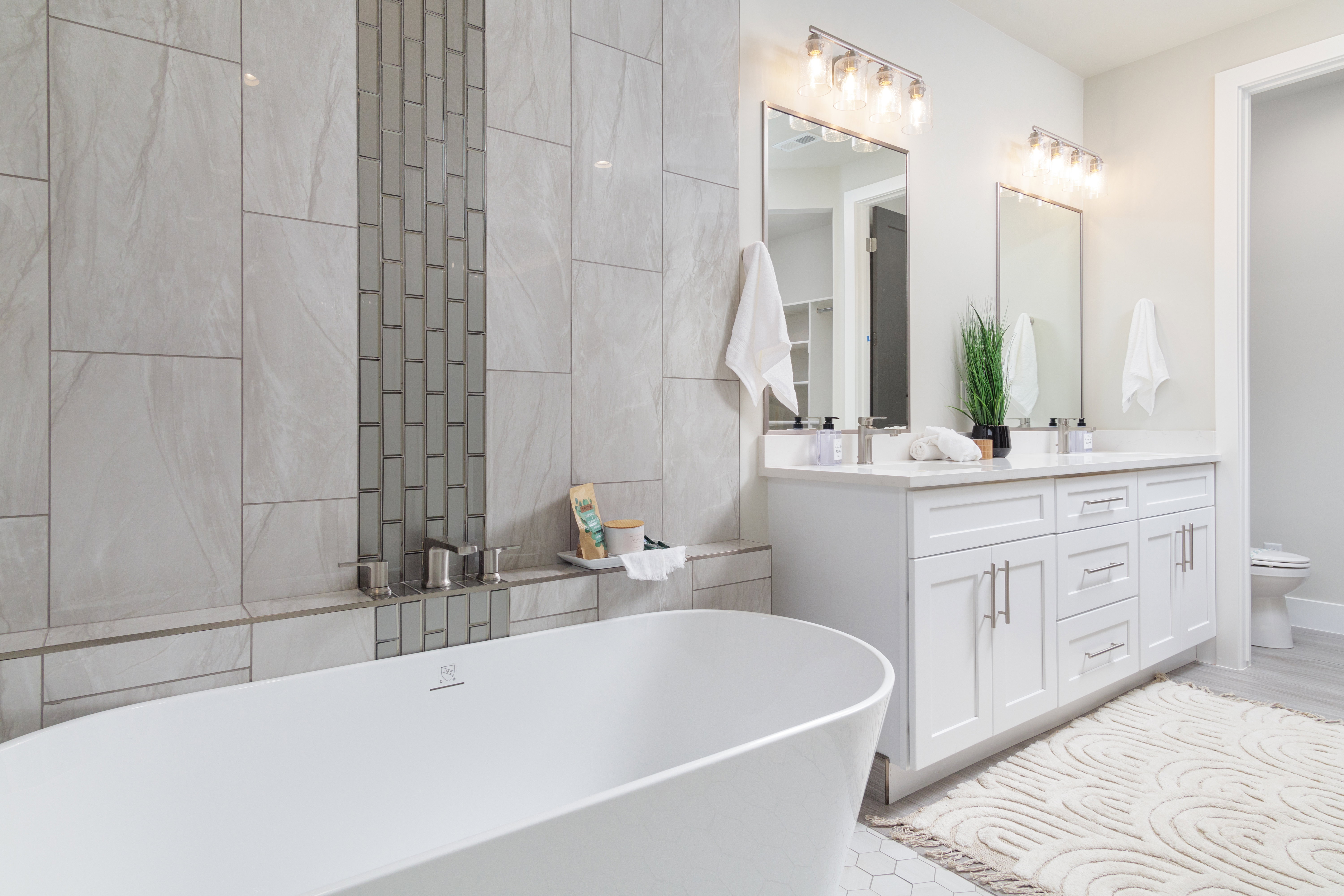 Bathroom with a freestanding tub, double vanity, and tile walls