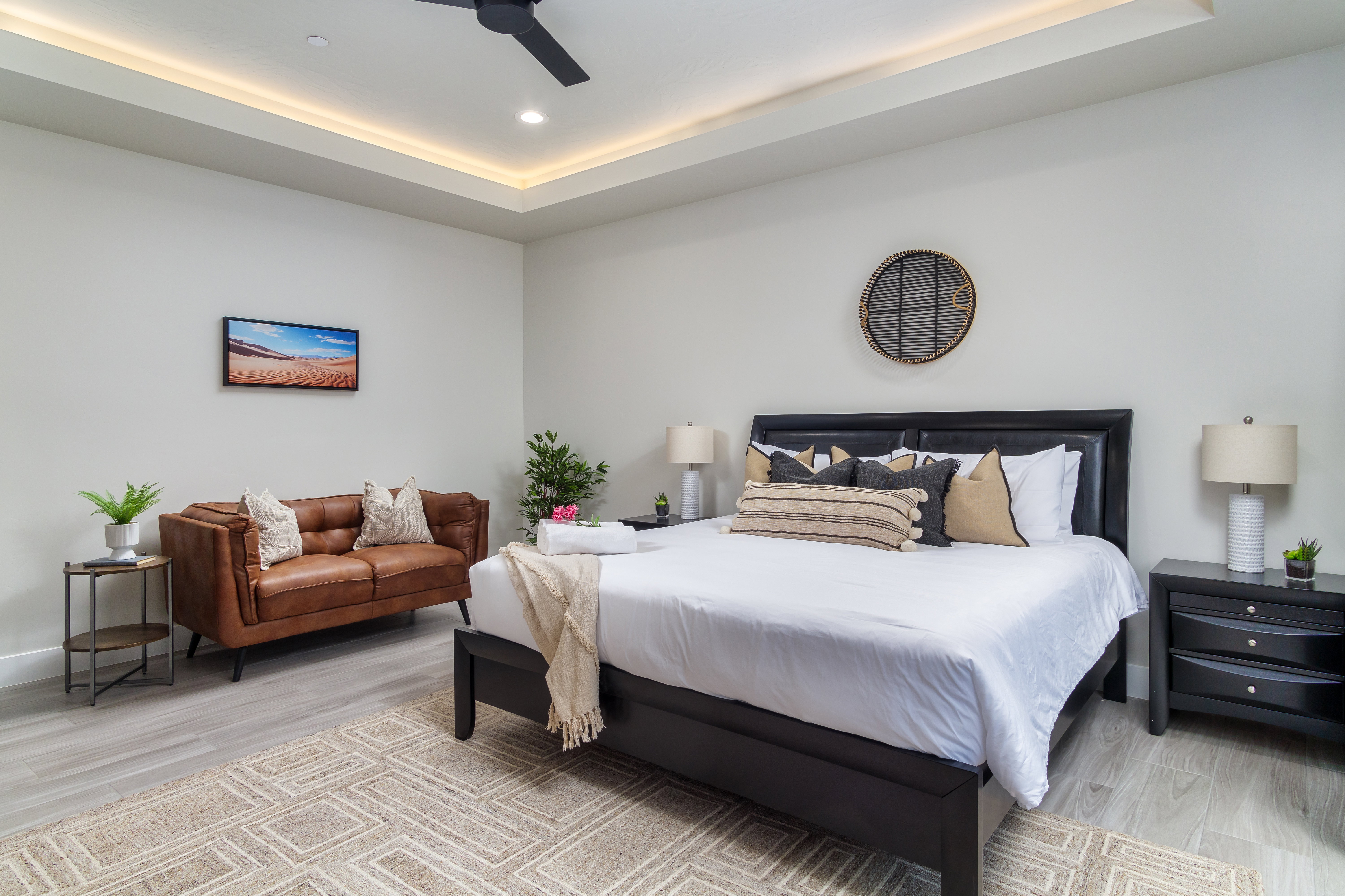 Bedroom featuring a tray ceiling, light wood finished floors, ceiling fan, and recessed lighting