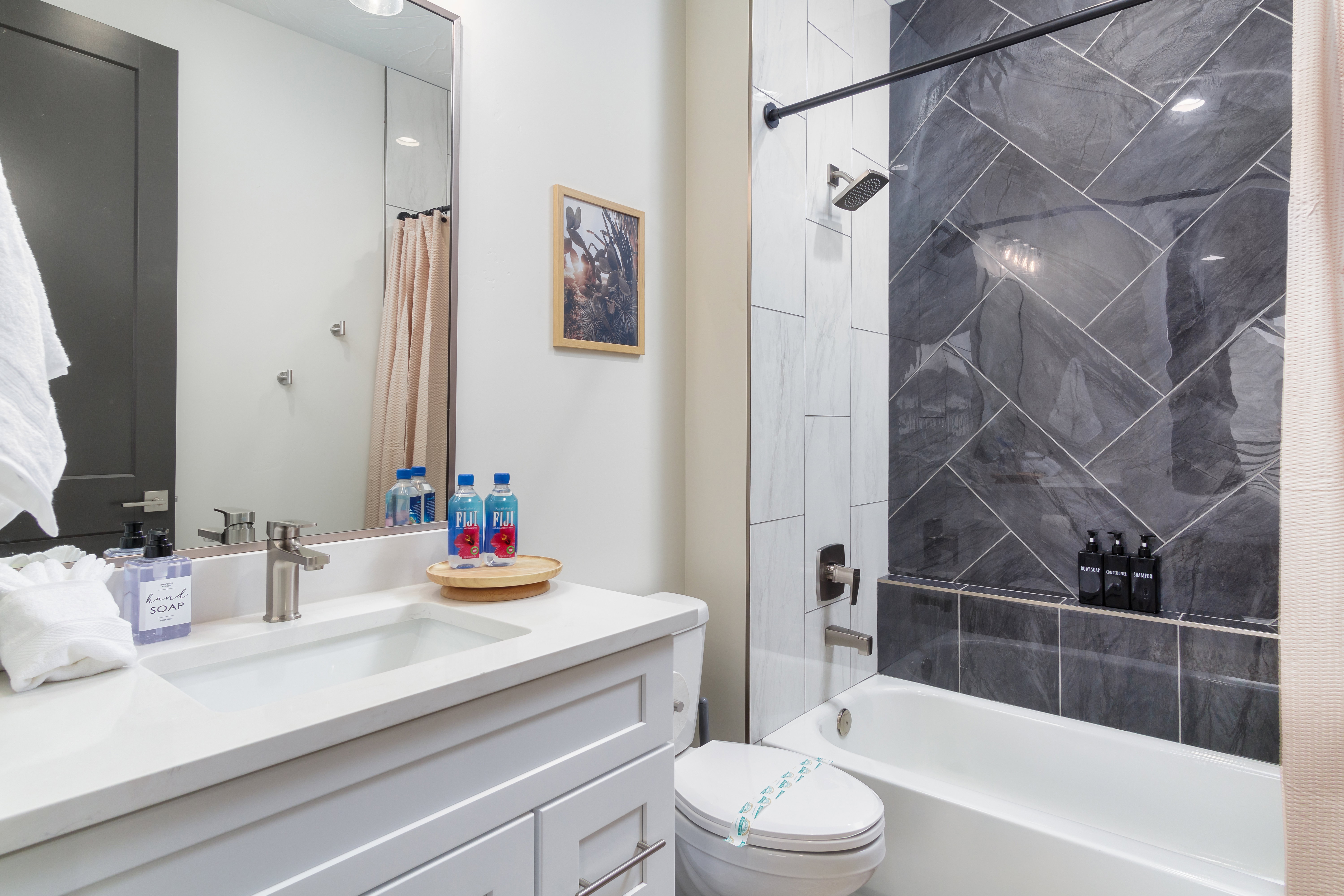 Bathroom featuring shower / bathtub combination with curtain and vanity