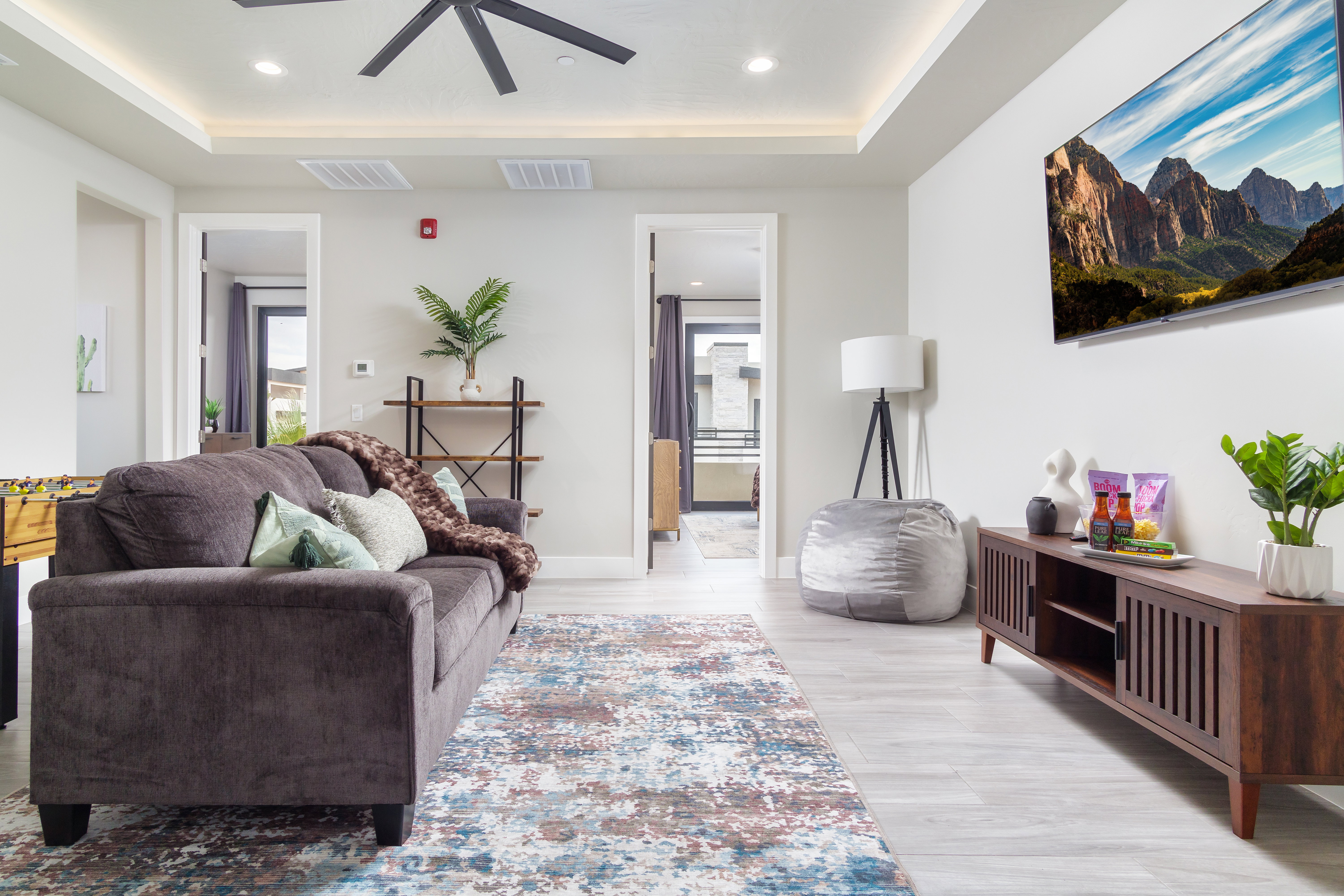Living area featuring healthy amount of natural light, recessed lighting, light wood-style flooring, a raised ceiling, and a ceiling fan