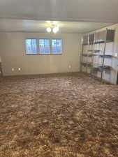 Spare room with a textured ceiling and dark carpet