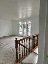 Staircase with a textured ceiling and carpet floors