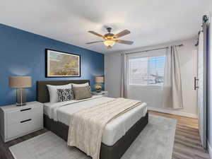 *THIS PHOTO IS VIRTUALLY STAGED TO SHOW POSSIBLE FURNITURE CONFIGURATIONS* Primary Bedroom with dark wood-style flooring and a ceiling fan