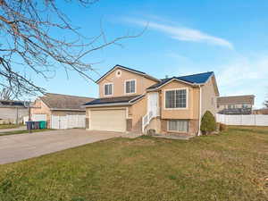 View of front of house with brick siding, driveway, an attached garage, and stucco siding