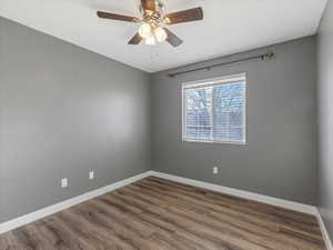 Bedroom #3 with wood finished floors and ceiling fan