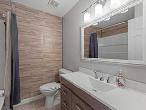 Hal; bathroom featuring vanity, curtained shower, and light tile patterned floors