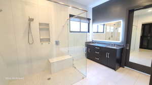 Primary Full bath with double vanity, a stall shower, and light tile patterned floors