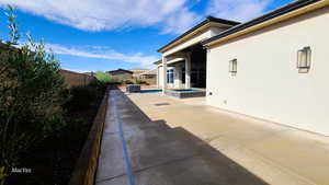 Fenced backyard featuring a patio and a pool with connected hot tub and planters