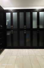 Primary walk in closet with enclosed cabinets