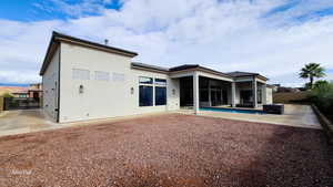Back of house featuring a fenced backyard, stucco siding, a patio area, and a gate for side yard parking