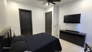 Bedroom 1 with light tile patterned flooring and ceiling fan