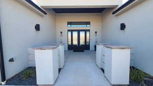 Doorway to property featuring stucco siding and a patio