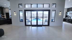 Interior space with recessed lighting, ceiling fan, a towering ceiling, and tile patterned floors