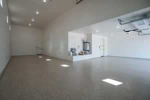 Garage featuring secured water heater and baseboards