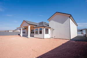 Rear view of house with a patio and stucco siding