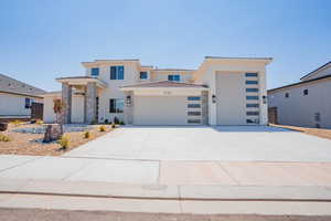 View of front of home featuring stone siding, a tiled roof, a garage, and stucco siding