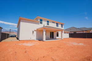 Rear view of house featuring a fenced backyard, a patio, and stucco siding