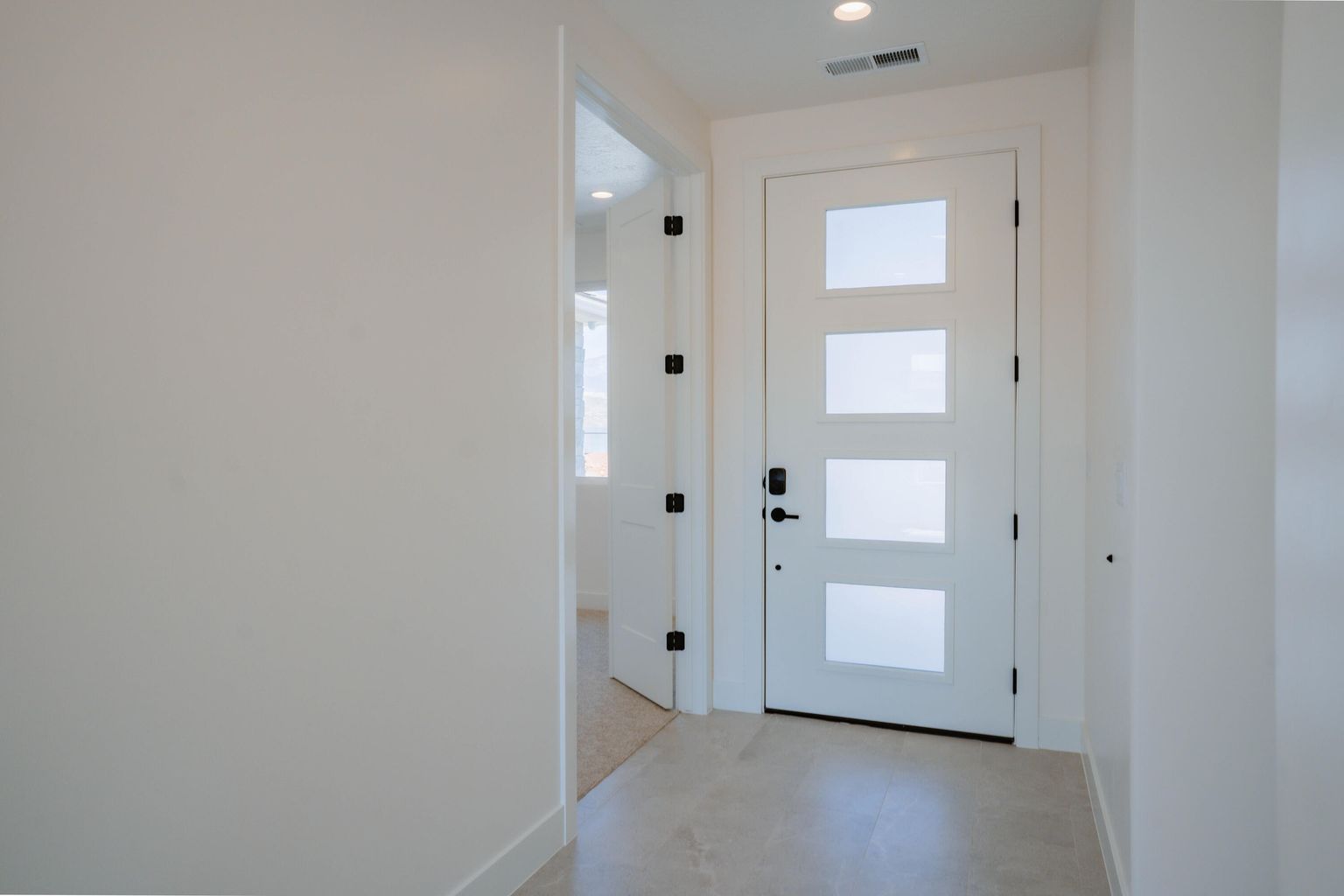 Entryway with tile patterned floors and recessed lighting