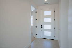 Entryway with tile patterned floors and recessed lighting