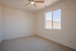 Spare room featuring a ceiling fan and light carpet
