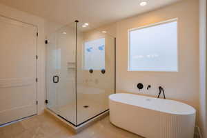 Full bath featuring a soaking tub, a shower stall, and recessed lighting