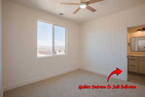 Unfurnished bedroom featuring light colored carpet, a ceiling fan, and connected bathroom