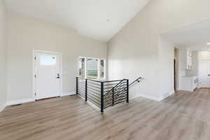 Entrance foyer featuring high vaulted ceiling, abundant natural light and light wood-style floors