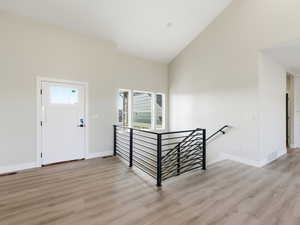 Entrance foyer featuring high vaulted ceiling, abundant natural light and light wood-style floors
