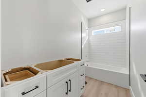 Full bathroom featuring light wood-type flooring and washtub / shower combination