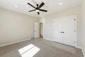 Unfurnished bedroom with light colored carpet, a ceiling fan, recessed lighting, and a closet