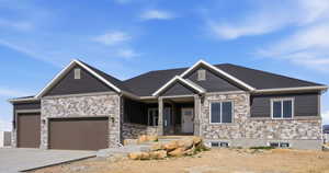 Craftsman house with a porch, an attached garage, stone siding, and driveway