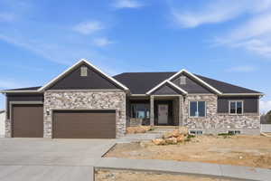 Craftsman house with an attached garage, a porch, driveway, and stone siding