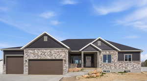 Craftsman-style house featuring an attached garage, covered porch, stone siding, and driveway