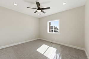 Empty room with light colored carpet, a ceiling fan, and recessed lighting