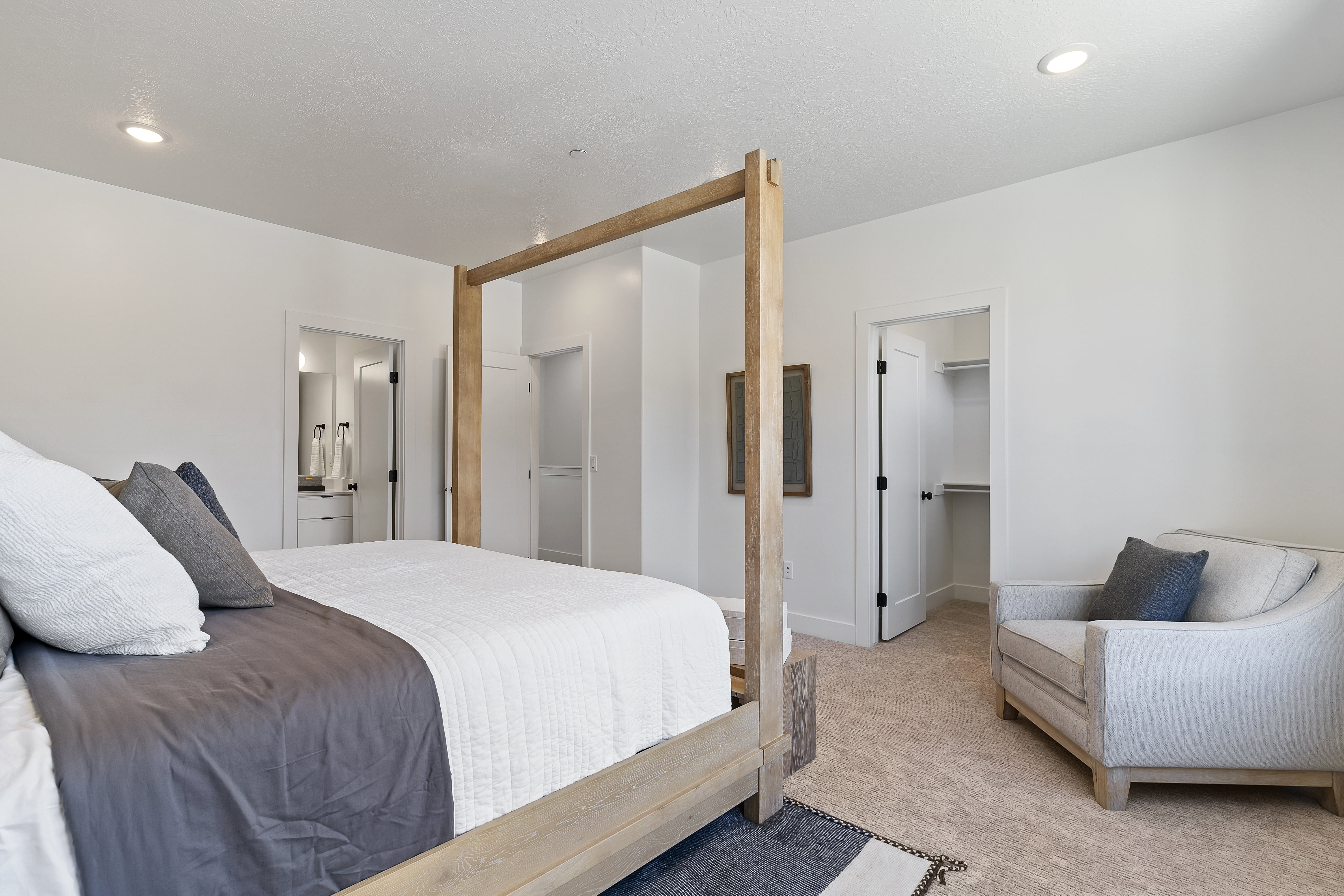 Carpeted bedroom featuring a walk in closet and ensuite bathroom