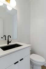 Half bathroom with vanity and toilet