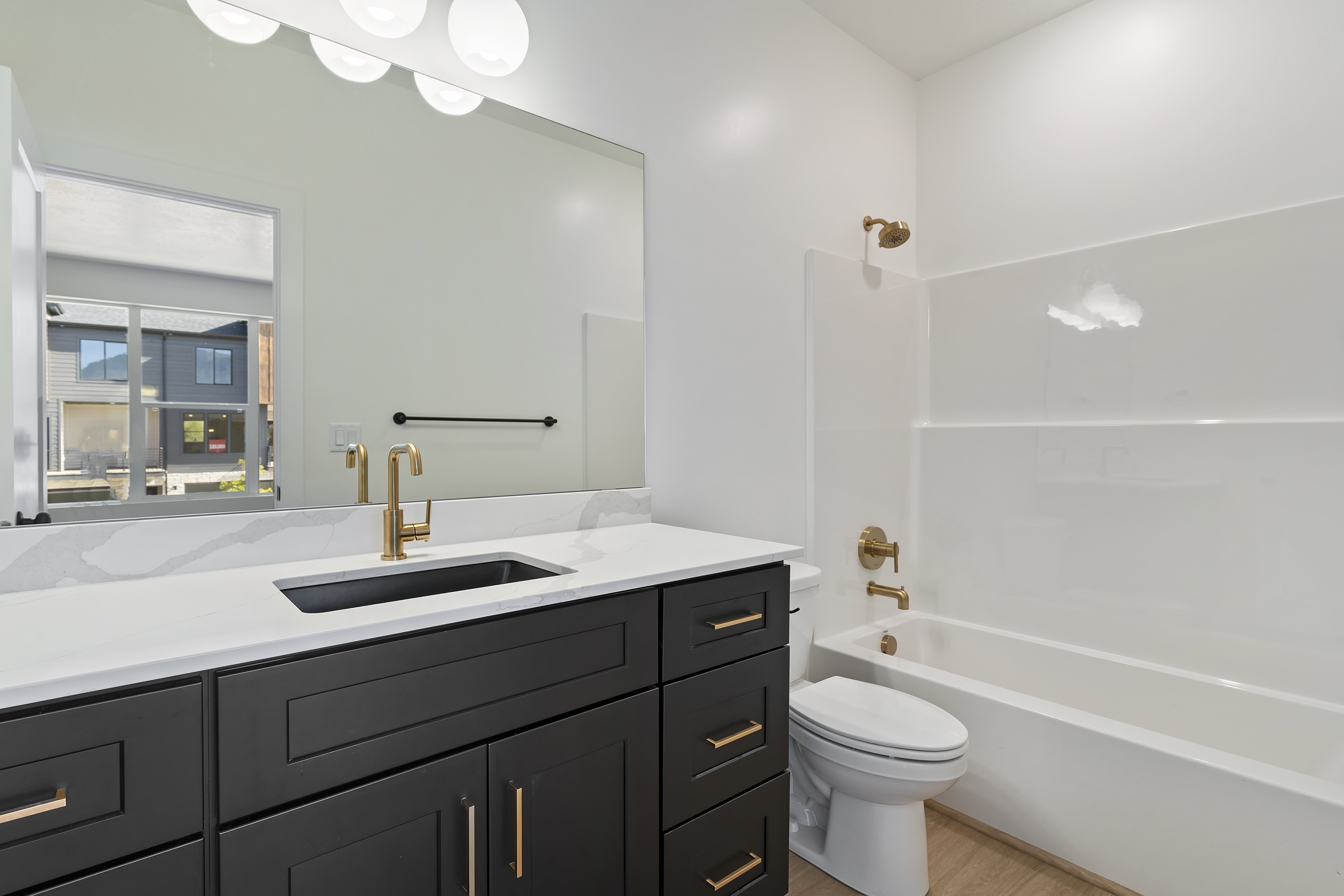 Full bath featuring bathing tub / shower combination, vanity, and light wood-type flooring
