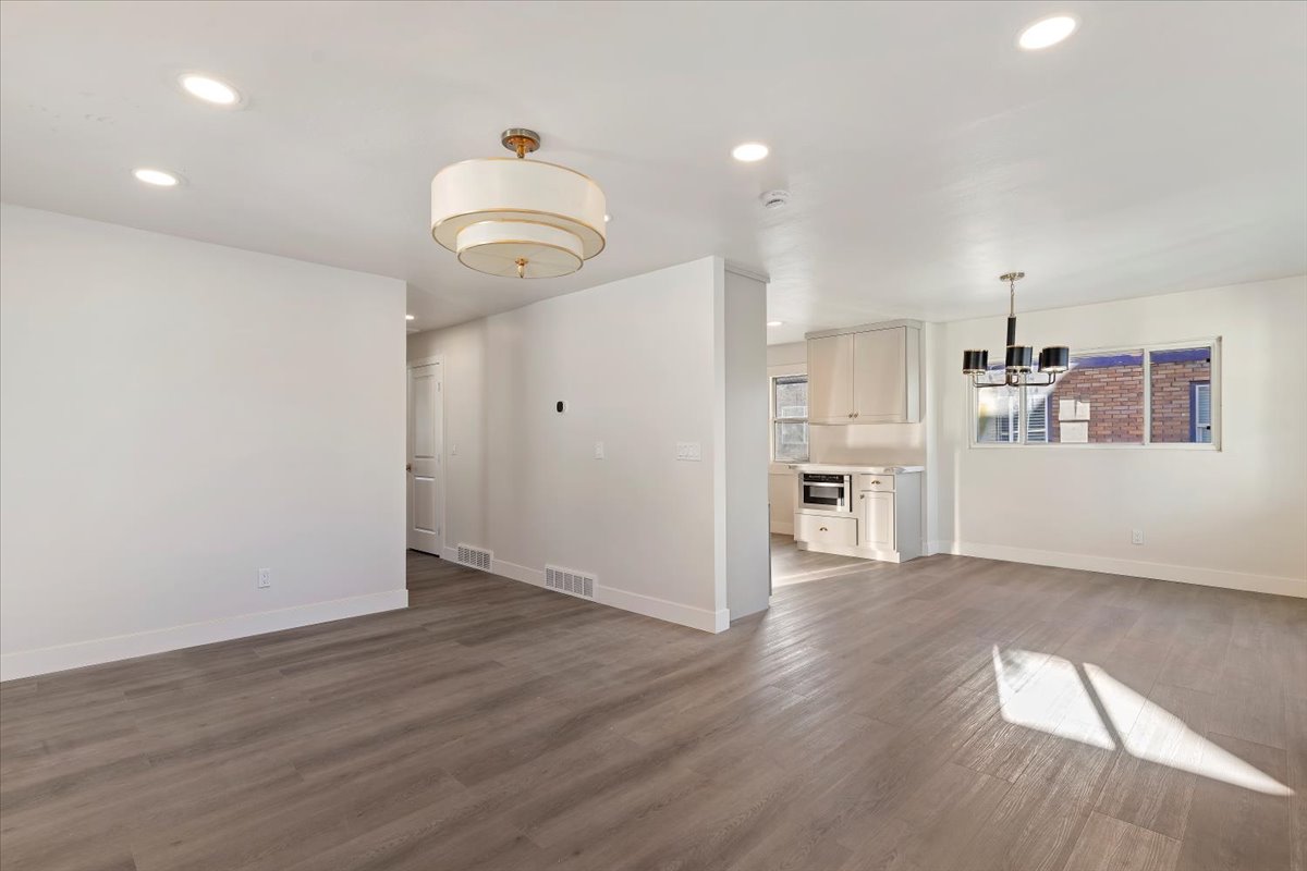 Unfurnished living room featuring recessed lighting, dark wood-type flooring, and a chandelier